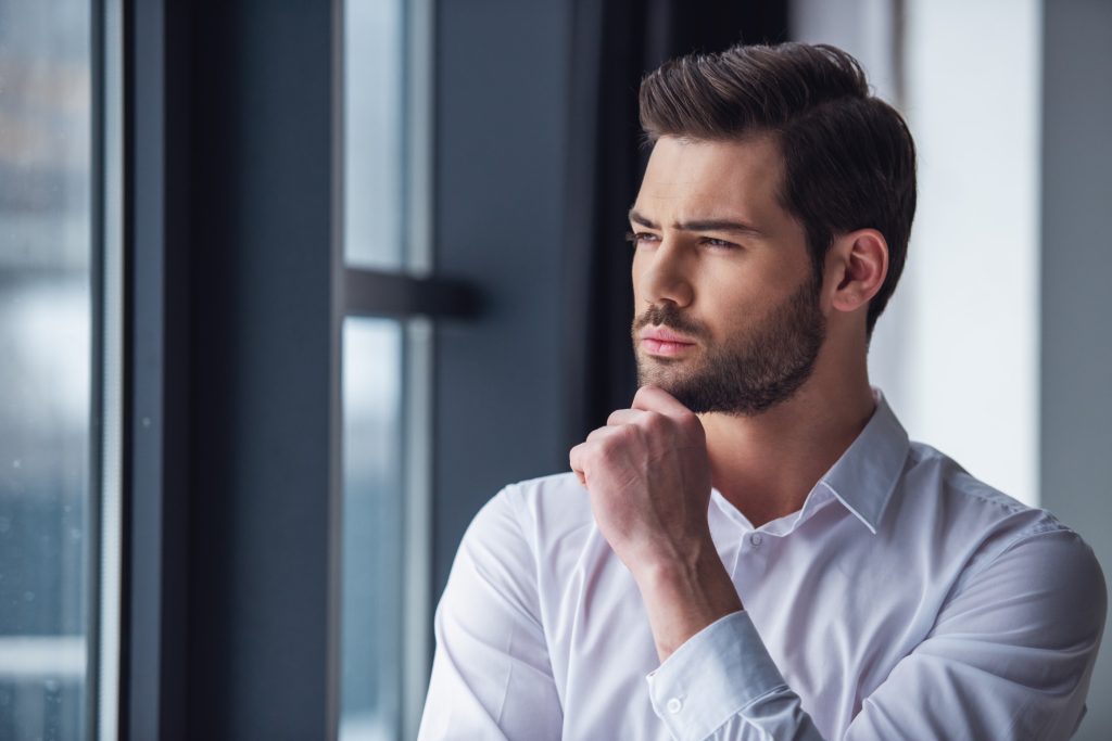 Handsome businessman in office
thinking about hair transplant