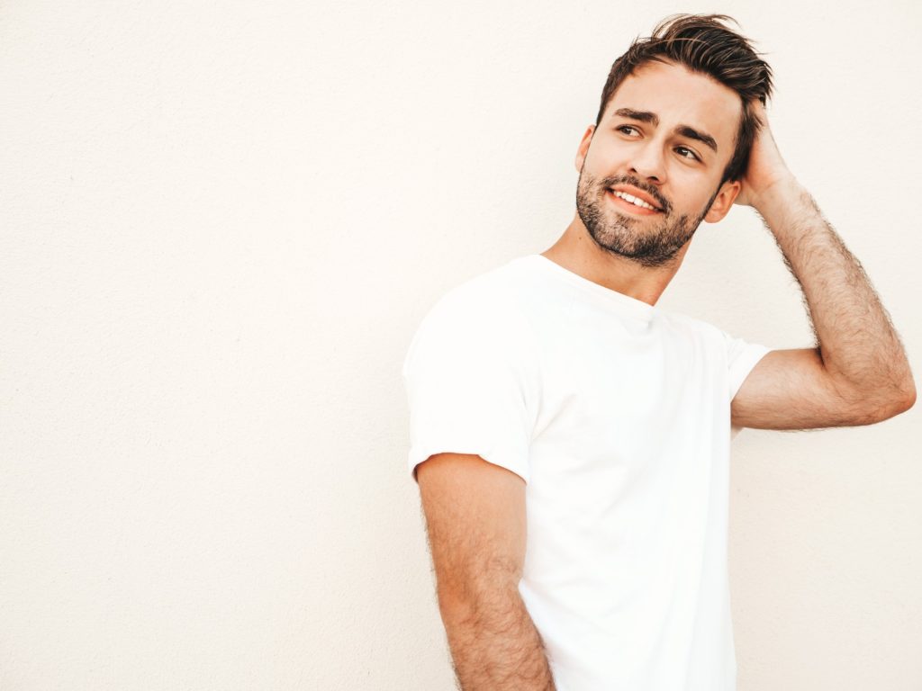 young handsome man posing after hair transplant